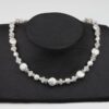 weiße Perlenkette mit Silberschnecken und Bergkristall dazu Silberverschluss handgemachtes Unikat auf schwarzem Pappaufsteller