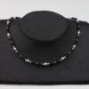 Lavaperlenkette mit Silberplättchen und grauen Perlen dazu Silberverschluss handgemachtes Unikat auf schwarzem Pappaufsteller